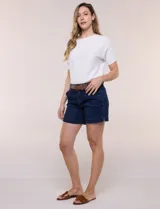 Short de algodón color beige, con pretina con pasadores, botón y cierre, bolsillos delanteros y bolsillos traseros abotonados. Incluye cinturón trenzado marrón.
