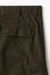 Pantalón cargo de sarga de algodón en color verde militar, con corte regular fit, múltiples bolsillos laterales con solapa y cierre de botón a presión.