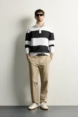 Pantalón regular fit de hombre color negro, confeccionado en tejido técnico ligero con cintura elástica, bolsillos frontales, bolsillos traseros de vivo y cierre frontal con cremallera y botón.
