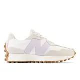 Championes New Balance modelo 327, de diseño contemporáneo inspirado en los años 70, color blanco con detalles en lila y superposiciones de gamuza gris claro, con el logotipo 'N' en el lateral y suela dentada de goma marrón que se extiende hasta el talón.