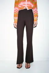 Pantalón de vestir color rosado, tiro bajo, con corte acampanado (flare) y costuras laterales marcadas. Cierre frontal con botón interior y gancho.