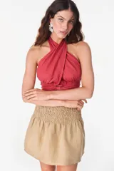 Top color blanco de lino italiano, con diseño de escote halter pronunciado, espalda descubierta y nudo frontal.