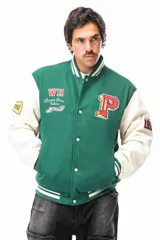 Campera estilo varsity de cuerpo verde con mangas largas en color crema. Presenta cierre frontal con botones a presión, cuello, puños y ruedo acanalados con rayas blancas. Incluye parches bordados en el pecho y en las mangas con motivos universitarios.