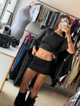 Top negro de corte crop con mangas anchas estilo murciélago y diseño holgado.
