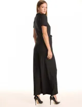 Enterito largo negro de seda fría, marca Sharagano. Presenta cuello a la base con frunces y escote en V con botones metálicos. La parte delantera tiene un detalle plisado vertical. Mangas cortas con terminación fruncida. Incluye un lazo de ajuste en la cintura y pantalón de pierna ancha y largo total. La espalda cuenta con cierre oculto.