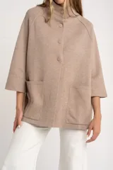 Cárdigan marrón de tejido de punto con cuello alto, manga 3/4 y cierre frontal con botones.