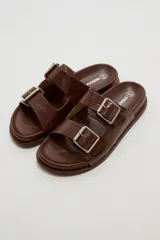 Sandalias planas de mujer con doble tira ancha en el empeine, hebillas metálicas plateadas y textura símil cocodrilo.