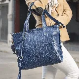 Bolso tipo tote azul con textura símil piel de cocodrilo, doble asa corta y correa larga extraíble.
