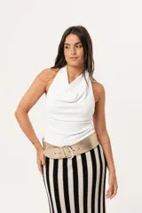 Top blanco de cuello volcado, confeccionado en tejido de punto suave y adaptable.