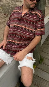 Camisa oversize de seda con estampado geométrico en tonos marrón, rojo y blanco.