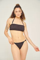 Micro tanga negra con estampado de cebra, totalmente forrada y con argollas laterales ajustables.