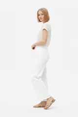Pantalón jean blanco de corte ancho, tiro alto y diseño liso.