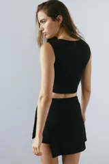 Top deportivo negro de corte cropped, con escote corazón, soutien incorporado y tejido funcional SculptMove que realza el contorno corporal.