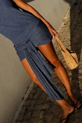 Vestido corto de punto con hilo brillante, escote drapeado, sin mangas y lazo decorativo para atar en la cintura.