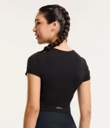 Remera deportiva tipo crop top de color negro, con cuello redondo y mangas cortas. Confeccionada en tejido de malla suave y elástico.