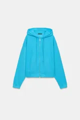 Sudadera con capucha ajustable con cordones, cierre frontal de cremallera, mangas largas, bolsillos tipo canguro y efecto lavado en color celeste.