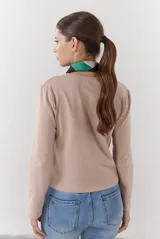 Cardigan negro de algodón con cuello redondo, cierre frontal de botones y costuras en contraste color ocre.