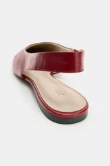 Zapato plano destalonado en piel de color rojo, con diseño de punta fina y detalle de costura central en la parte delantera. Cuenta con tira trasera y suela baja.