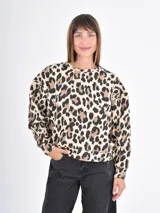 Buzo de cuello redondo y manga larga con estampado animal print de leopardo en tonos beige, marrón y negro. Presenta un corte holgado y puños y ruedo acanalados.