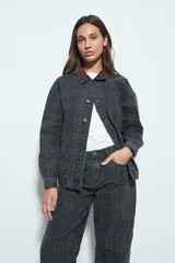 Sobrecamisa de algodón con estampado de cuadros, corte relajado, bolsillos frontales y cuello de pana en contraste. Cuenta con cierre frontal de botones y diseño de estilo utilitario.
