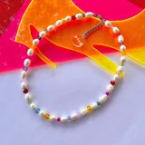 Collar corto de perlas de río blancas con cristales checos de colores y cierre de mosquetón plateado.