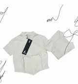 T-shirt blanca de algodón, corte slim con cuello alto y mangas cortas. Presenta costuras estilo corset que se ajustan al cuerpo.