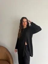 Conjunto de dos piezas color gris melange, confeccionado en tela de lanilla, compuesto por un buzo de manga larga con diseño cruzado al frente y un pantalón largo de corte holgado y tiro alto.