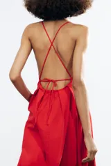 Vestido largo rojo de Zara Woman Collection confeccionado en hilatura con mezcla de algodón. Escote pico y tirantes finos cruzados en la espalda ajustable con lazadas. Tiene bolsillos laterales, detalle de pliegues en la cintura y cierre en la espalda con cremallera oculta en la costura.