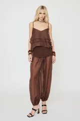Blusa marrón sin mangas con tirantes finos, escote en V y diseño escalonado de volados con cintura elástica fruncida.