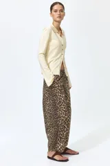 Pantalón tobillero en denim de algodón con estampado de leopardo, cintura elástica y bolsillos al bies. Modelo de corte holgado con piernas barrel y costuras laterales avanzadas.