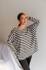 Buzo de viscosa de corte holgado, con diseño a rayas horizontales en blanco y negro, escote bote y mangas largas caídas.