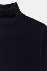 Jersey de punto confeccionado en lana, con cuello subido y manga larga.