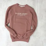 Buzo color rosa viejo de algodón con cuello redondo, puños y cintura acanalados. Estampa frontal con el texto "DUXON JEANS LOS ANGELES EST. 1982" en color blanco.
