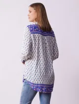 Camisa blanca con estampado floral en azul, de manga larga y cuello con solapa.