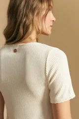 Remera de manga corta en tejido acanalado, con escote en V y detalles de puntilla en el borde del escote y en las mangas. Presenta un ajuste entallado al cuerpo.