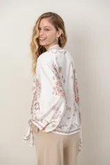 Camisa de seda modelo pañuelo, de color amarillo con estampado estilo mandala y flores, cuello redondo y cierre frontal con botones.