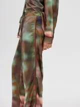 Pantalón de tiro alto con corte recto y holgado, confeccionado en tela liviana con estampado tipo tie-dye en tonos azul y blanco.