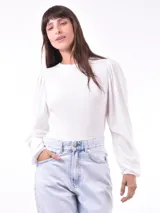 Remera color caqui de tejido acanalado, con mangas largas abullonadas en los hombros y puños ajustados.