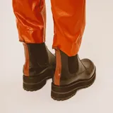 Botas tipo chelsea de cuero marrón con suela track de goma negra. Presentan una combinación de texturas en el cuero y elásticos laterales negros.