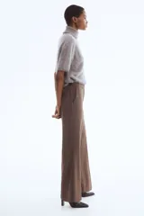 Pantalón de corte bootcut con estampado de pata de gallo en tonos marrones. Presenta cierre frontal con pretina prolongada, botón oculto y corchetes, además de raya marcada en la parte delantera y trasera, bolsillos laterales al bies y bolsillos traseros ribeteados.