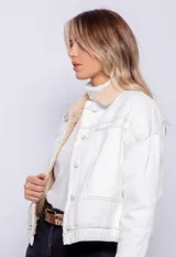 Campera de jean con corderito en el cuello y el interior, bolsillos frontales, cierre de botones metálicos y elástico en la cintura.