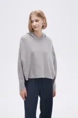 Sweater gris melange medio con capucha y corte cropped.