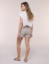 Short blanco de tiro medio y calce relajado, confeccionado en mezcla de algodón y viscosa. Cuenta con cintura elastizada con cordón ajustable, bolsillos delanteros tipo parche, bolsillos traseros ojal simulados y ruedo con vuelta.