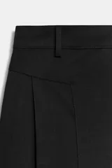 Pantalón de tiro medio con diseño de pierna ancha y pinzas frontales. Cuenta con bolsillos laterales ocultos, falsos bolsillos traseros de vivo, trabillas en la cintura y cierre frontal con cremallera y ganchos metálicos.