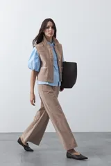 Pantalón de pana de corte wide leg, color marrón oscuro, con calce relajado y detalle de bordado en el borde de los bolsillos delanteros.
