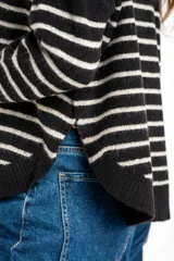 Sweater de tejido de punto color beige melange, con cuello redondo y mangas largas. Presenta rayas horizontales en tonos verde oliva, lila, marrón, naranja y rosado.