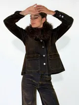 Chaqueta de denim con efecto desgastado, cuello con detalle de piel sintética, cierre frontal con botones metálicos y bolsillos frontales con solapa.