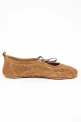 Chatita de gamuza color camel con costuras decorativas en hilo blanco y cordones ajustables en la parte superior. Presenta suela de goma dentada y tirador en el talón.