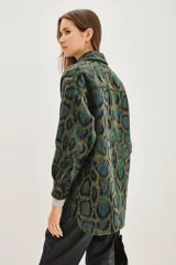 Tapado tipo sobrecamisa con estampado animal print, de corte recto y largo a la cadera. Presenta cuello camisero, cierre frontal con botones y dos bolsillos frontales con solapa.