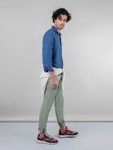 Pantalón chino azul marino de corte slim fit, confeccionado en gabardina con 77% algodón, 20% de algodón reciclado y 3% elastano. Presenta bolsillos delanteros y traseros. Tiene un lavado final con enzima ácida que le da un aspecto desgastado.